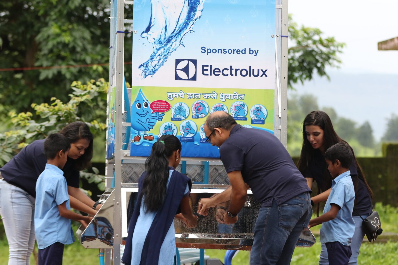 Electrolux volunteers showing children how to wash their hands scaled